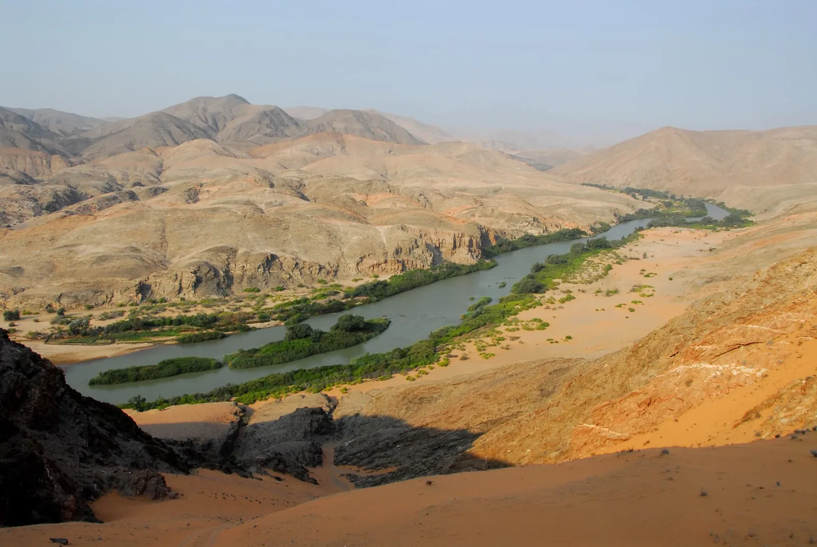 Der Kunene windet sich als grünes Band durch die Bergwüste des Kaokoveld im Nordwesten Namibias