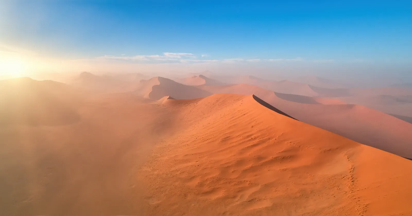 Blick vom Dünenkamm über die roten Dünen der Namib bei Sossusvlei in Namibia im Morgendunst