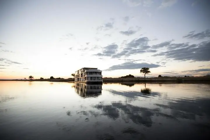 Sonnenuntergang über dem Zambezi River an der Nordgrenze von Botswana mit Silhouetten von Bäumen Sonnenuntergang über dem Zambezi River an der Nordgrenze von Botswana mit Silhouetten von Bäumen