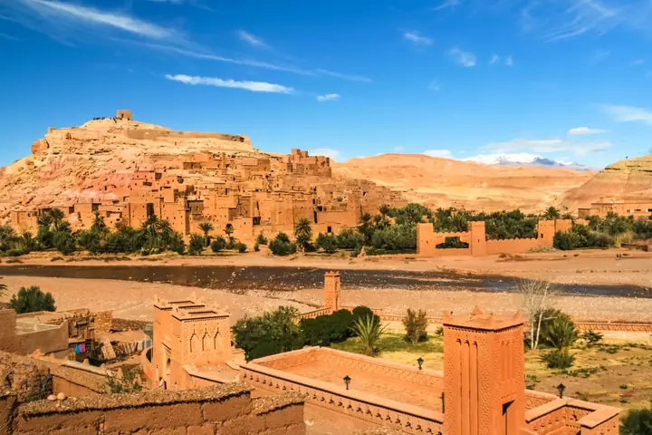 Lehmfestung Aït Benhaddou in Marokko im Abendlicht vor den Gipfeln des Hohen Atlas