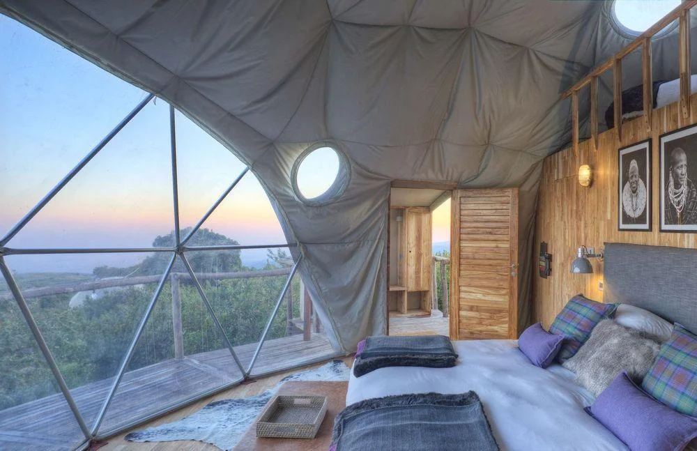 Interieur eines geodätischen Zeltes von The Highlands im Ngorongoro Hochland in Tansania mit Bett und Ausblick