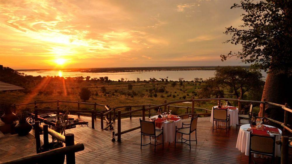 Sonnenuntergang über dem Chobe-Fluss von der Holzterrasse der Ngoma Safari Lodge in Botswana
