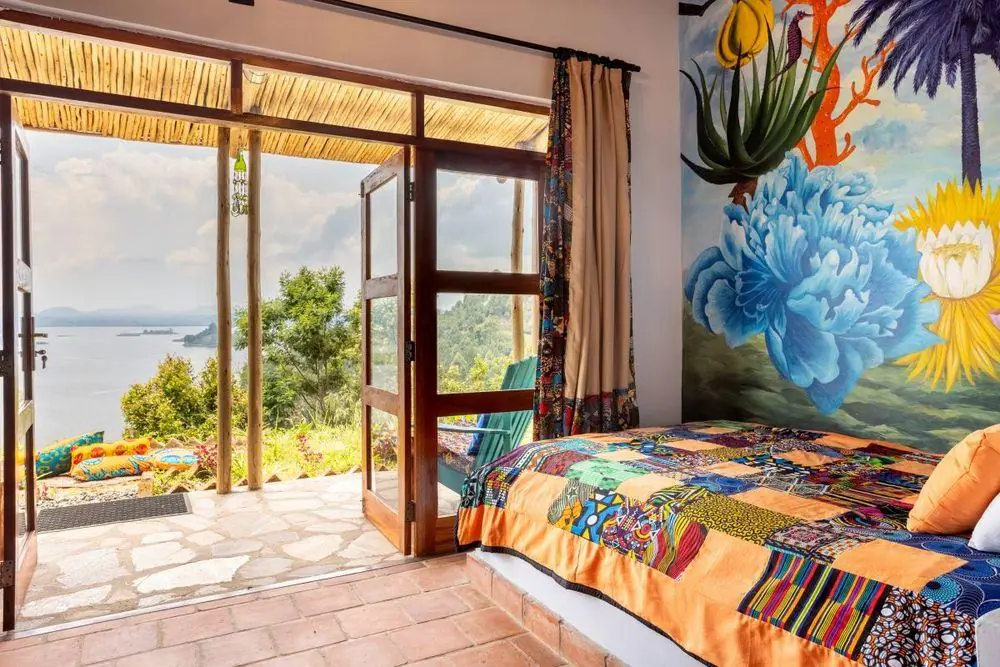 Bunt eingerichtetes Zimmer der Chameleon Hill Lodge mit Blick auf den Bunyonyi-See, Uganda