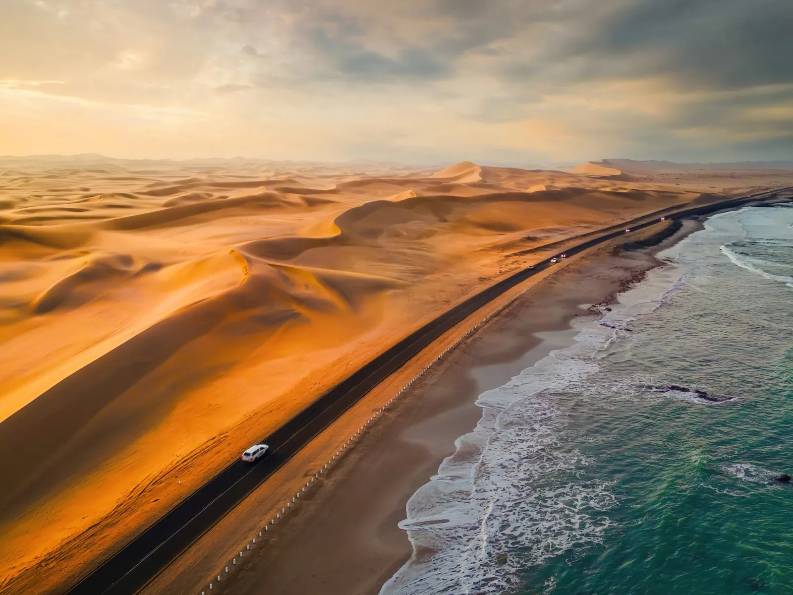 Luftbild der Küstenstraße zwischen den Dünen der Namib und dem Atlantik bei Walvis Bay in Namibia