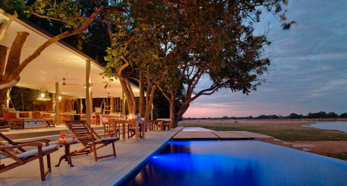 Pool und Terrasse des Time + Tide Chinzombo am Luangwa River in Sambia bei Sonnenuntergang