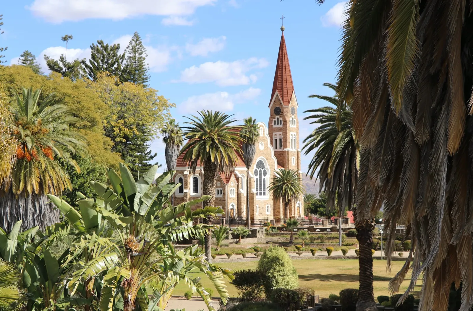 Christuskirche in Windhoek in Namibia zwischen Palmen und Gärten im Licht des Hochlands