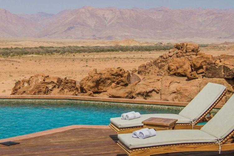 Pool und Liegen der Sorris Sorris Lodge mit Blick auf die Felslandschaft des Damaraland, Namibia