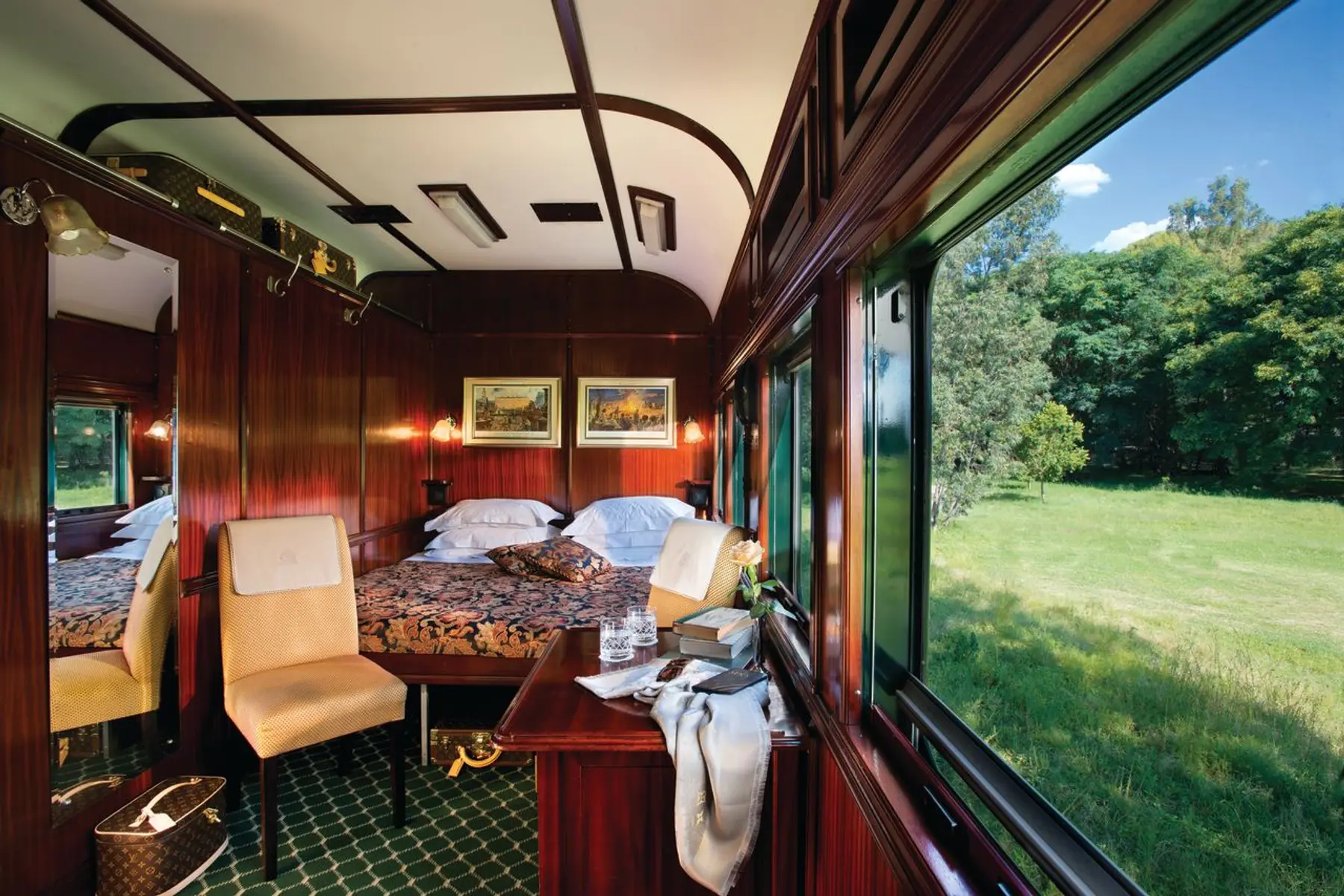 Suite mit Mahagoni-Vertäfelung und Panoramafenster im Luxuszug Rovos Rail in Südafrika