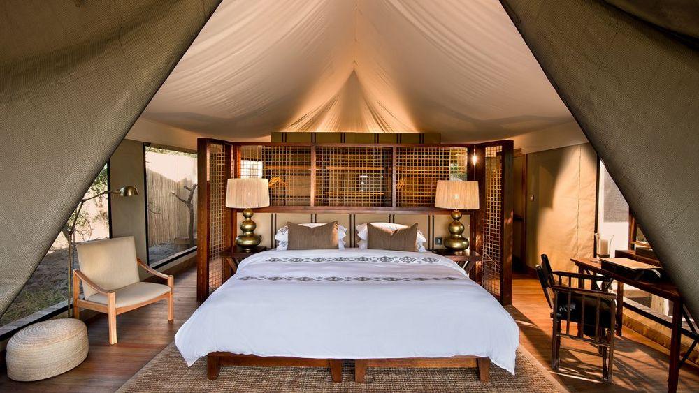 Zeltcamp &Beyond Nxabega Okavango Tented Camp unter hohen Bäumen am Wasser im Okavango Delta in Botswana